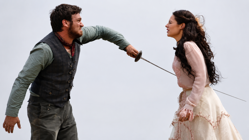 Cena de Além do Tempo mostra um homem apontando uma espada para uma mulher durante um confronto decisivo na primeira fase da novela da Globo.