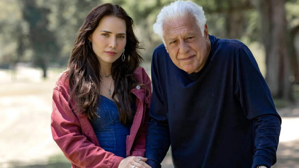 Letícia Colin e Antonio Fagundes em cena da novela Quem Ama Cuida, lado a lado ao ar livre, durante um momento marcante da trama.